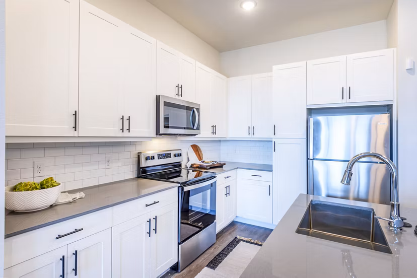 Modern kitchen featuring stainless steel appliances and granite countertops at The Waterview Apartments in Greystar community