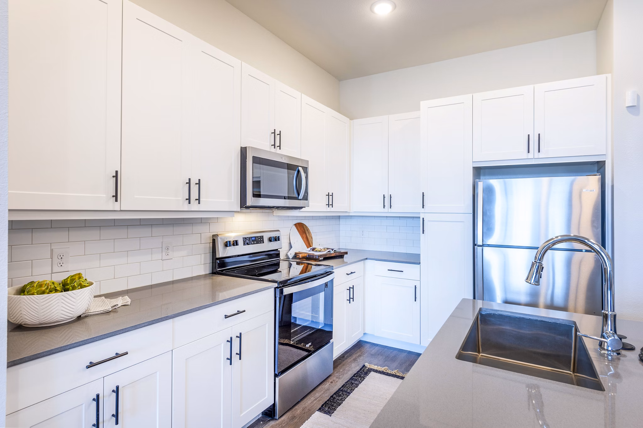 Modern kitchen featuring stainless steel appliances and granite countertops at The Waterview Apartments in Greystar community