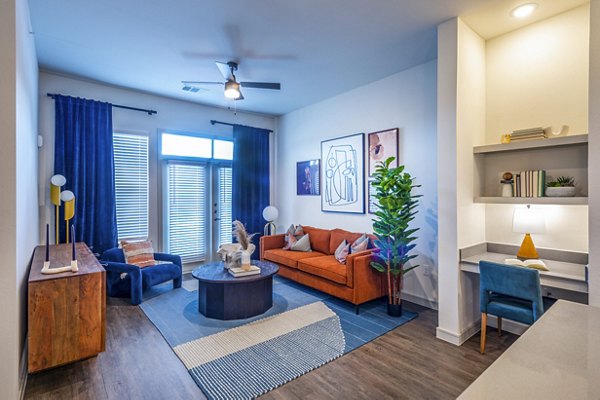 Spacious living room with modern furniture and large windows in The Waterview Apartments