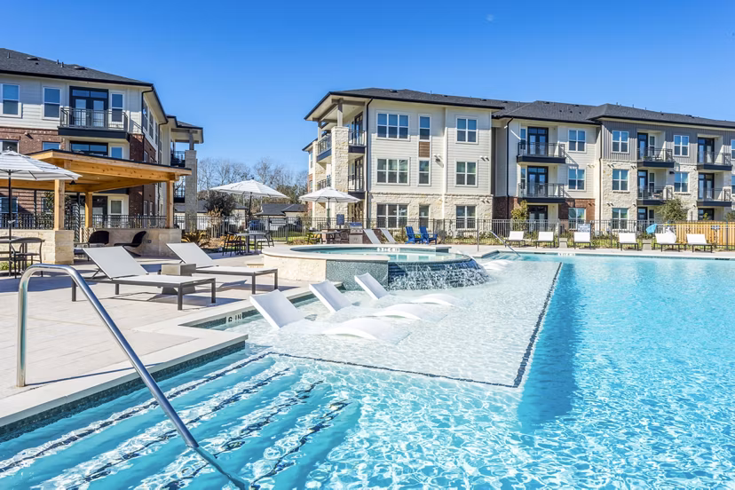 Relax by the infinity pool at The Waterview Apartments, featuring luxurious poolside seating and stunning water views