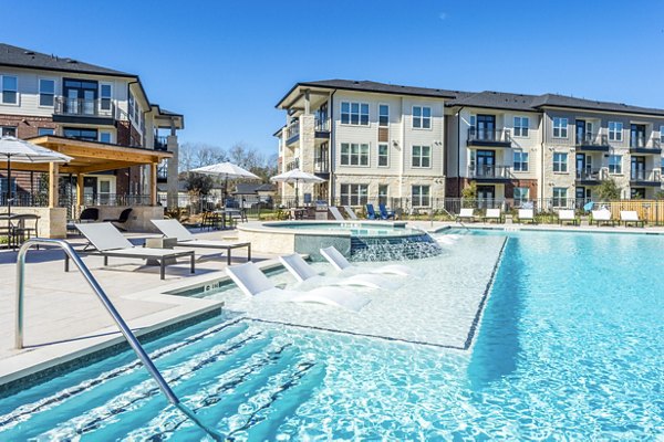 Relax by the infinity pool at The Waterview Apartments, featuring luxurious poolside seating and stunning water views