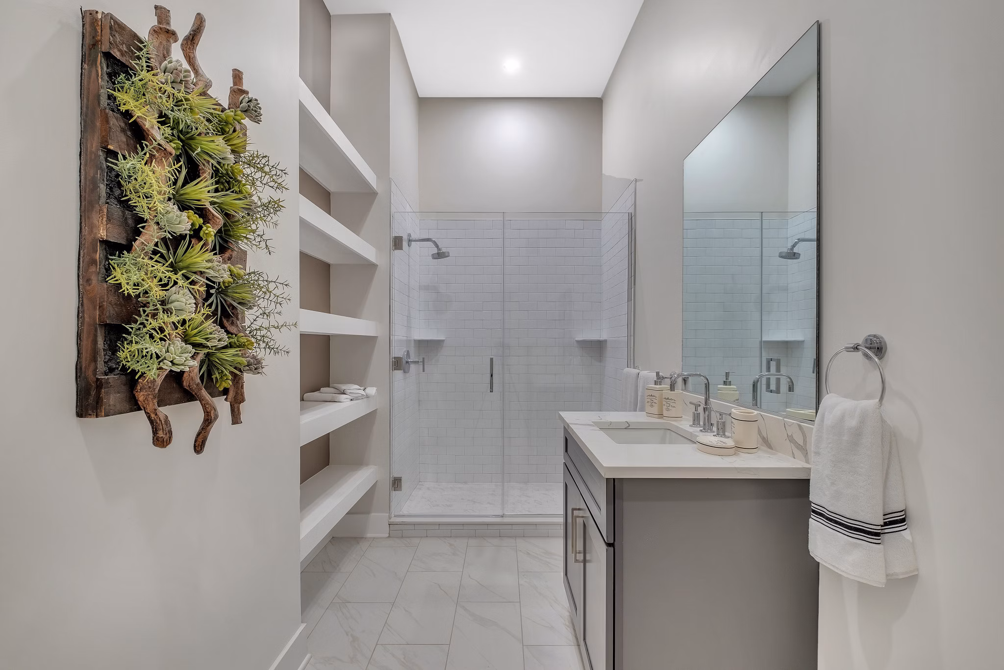 Elegant bathroom with marble countertops and glass shower at Icon Riverwalk Apartments