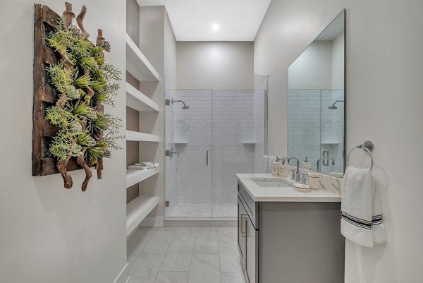 Elegant bathroom with marble countertops and glass shower at Icon Riverwalk Apartments