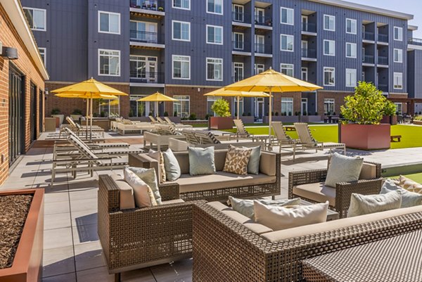 Patio with cozy seating and river views at Icon Riverwalk Apartments, a luxury Greystar property in an urban setting