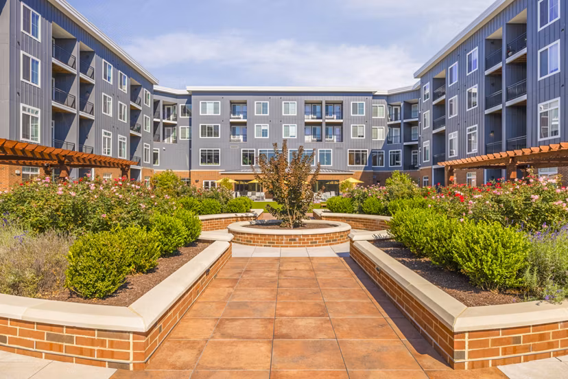 Courtyard patio with lush greenery at Icon Riverwalk Apartments, offering tranquil outdoor space for relaxation
