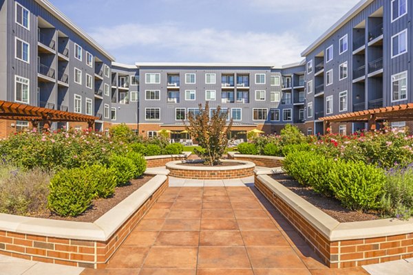 Courtyard patio with lush greenery at Icon Riverwalk Apartments, offering tranquil outdoor space for relaxation