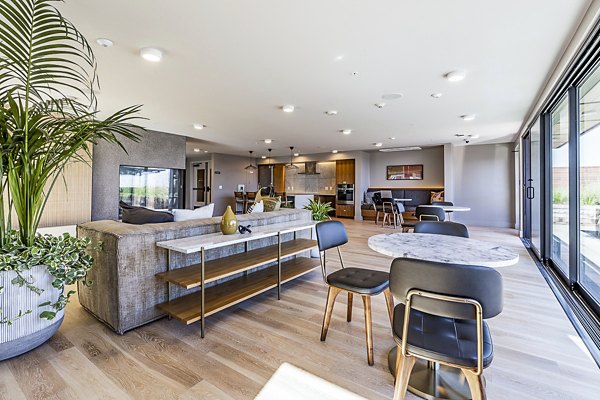 Modern clubhouse featuring cozy seating and ample natural light at Mason & Main Apartments