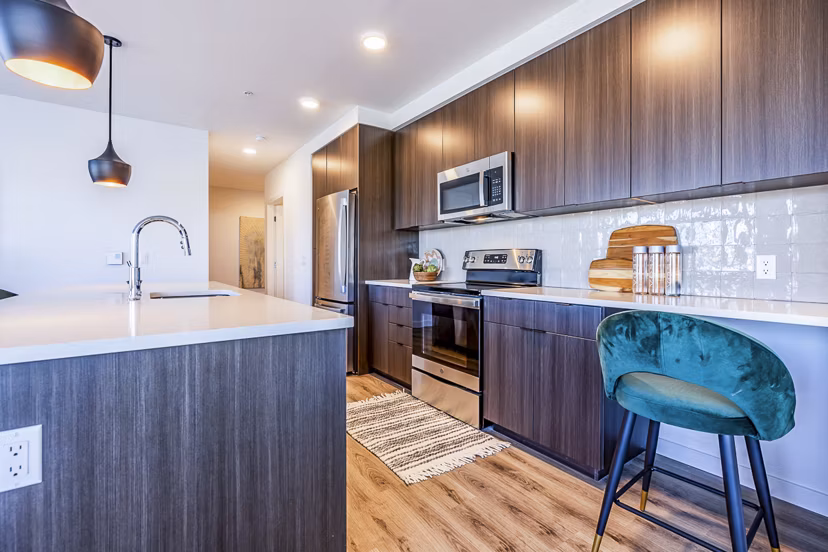 Spacious kitchen with modern appliances and island seating at Mason & Main Apartments