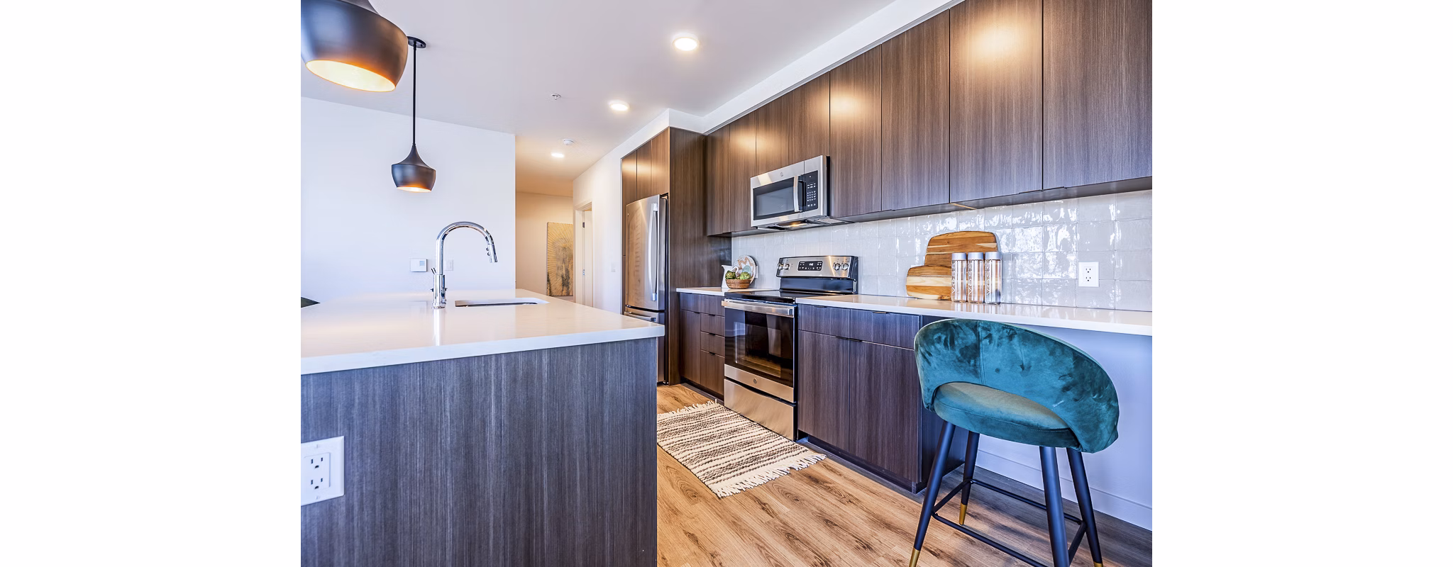 Spacious kitchen with modern appliances and island seating at Mason & Main Apartments
