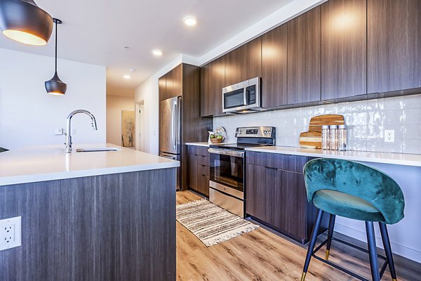 Spacious kitchen with modern appliances and island seating at Mason & Main Apartments