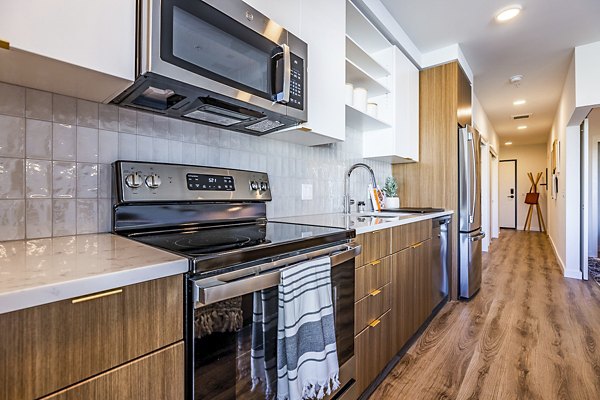Modern kitchen with stainless steel appliances at Mason & Main Apartments