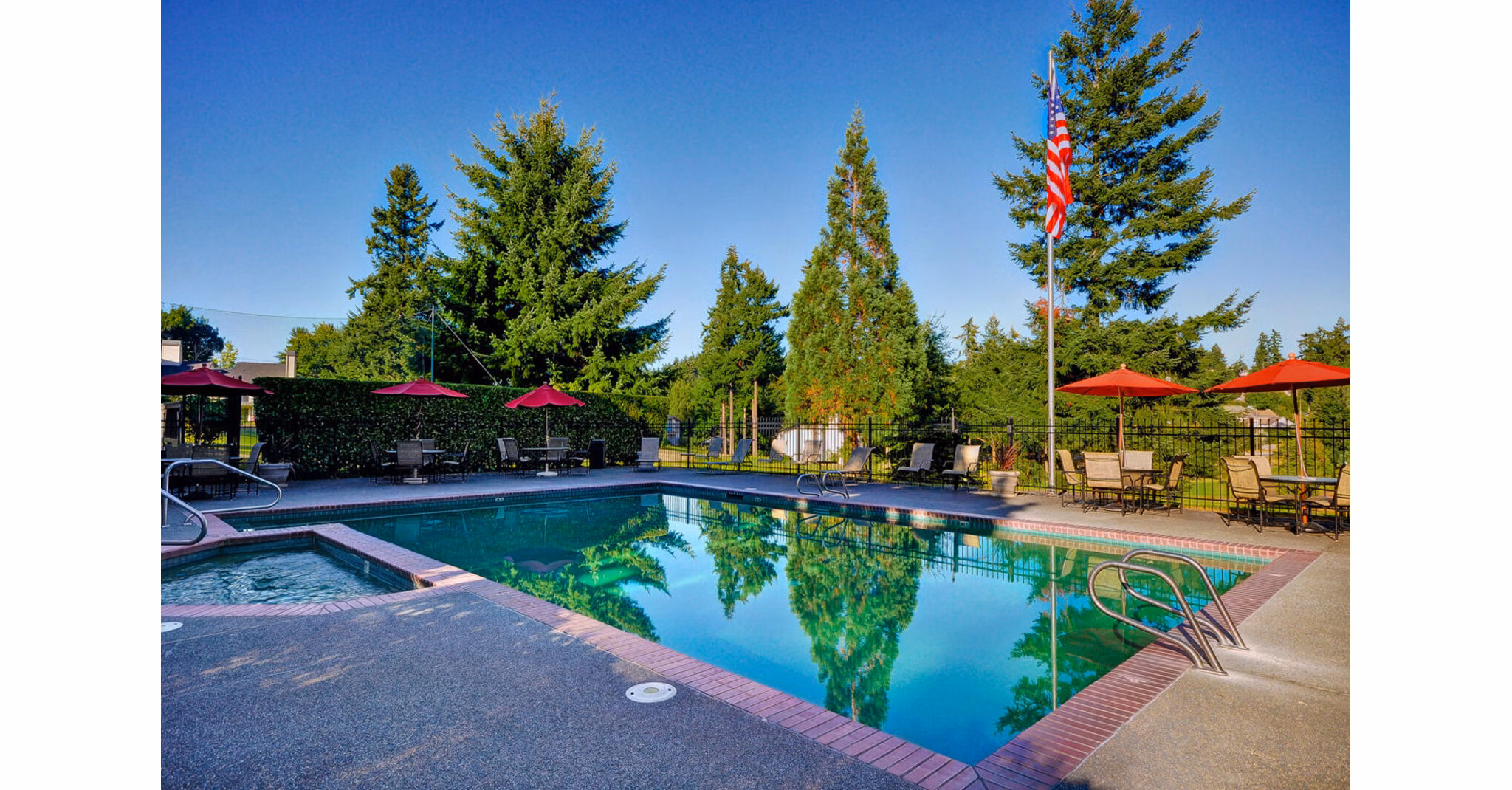 Inviting pool area at The Fairways Apartments with luxurious sun loungers and surrounding greenery, offering a relaxing oasis within the community