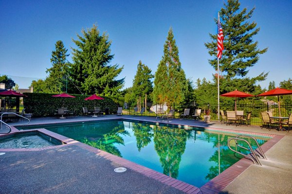 Inviting pool area at The Fairways Apartments with luxurious sun loungers and surrounding greenery, offering a relaxing oasis within the community