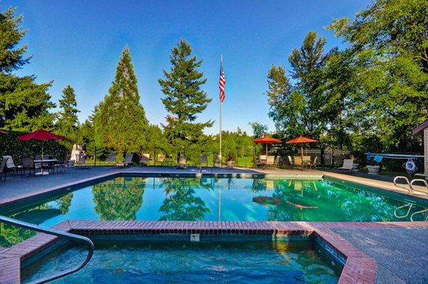 Luxurious outdoor pool area at The Fairways Apartments with sun loungers and lush greenery, perfect for relaxation and leisure activities