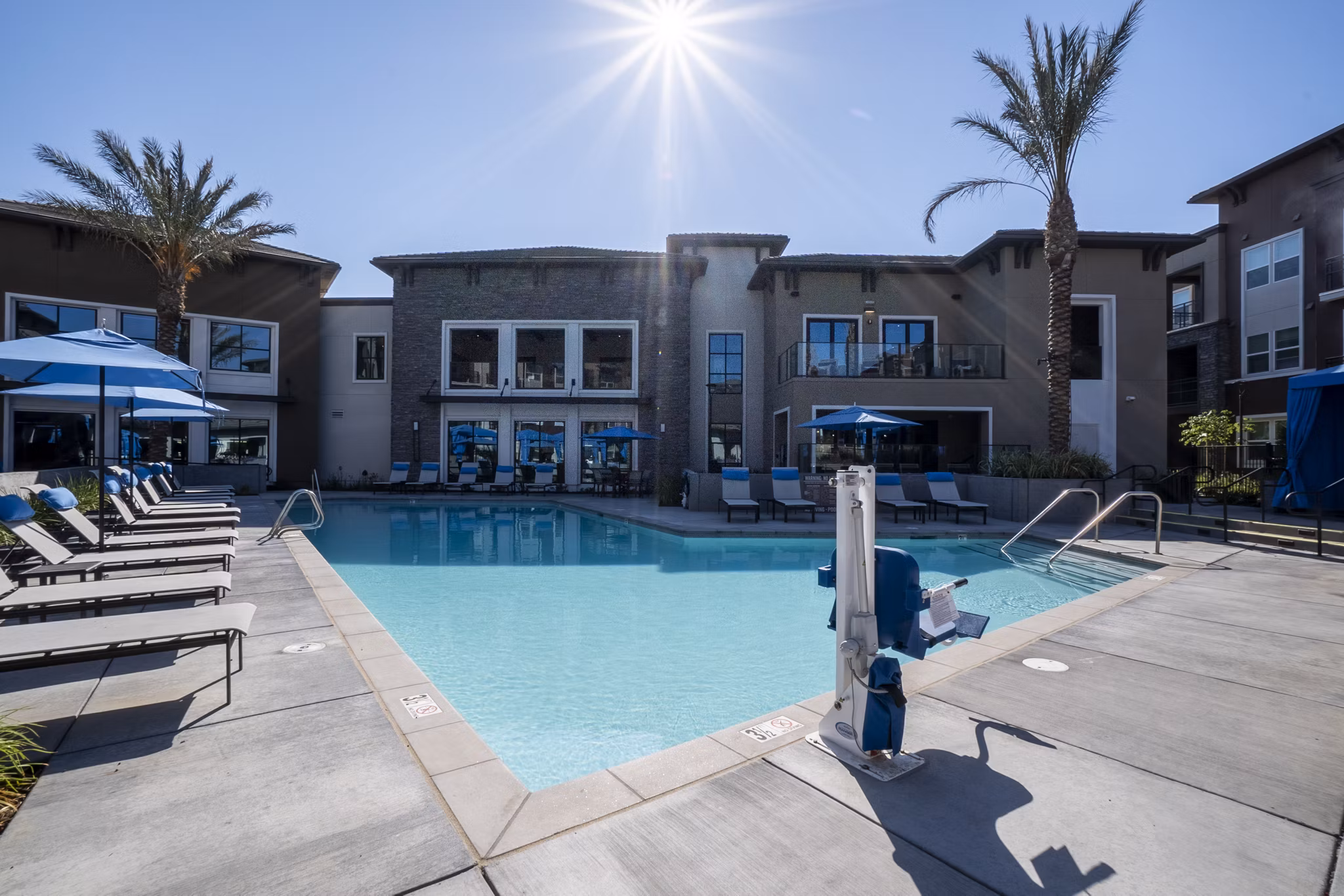 Outdoor pool with lounge chairs at The Core Natomas Apartments, offering luxury leisure for residents