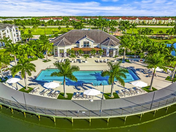 Relaxing outdoor pool area with lush palm trees at Estero Oaks Apartments luxury apartments in Estero