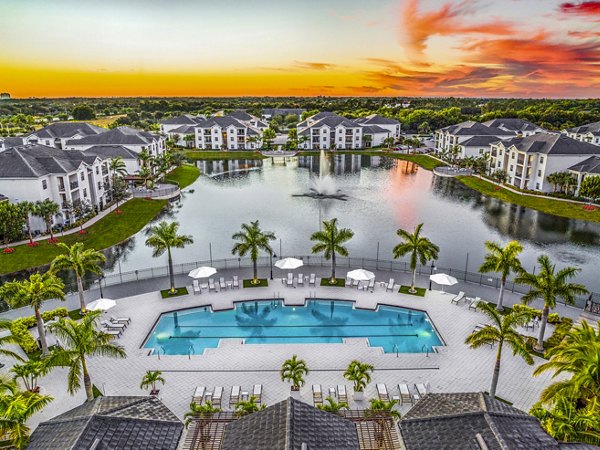 Sunlit resort-style pool at Estero Oaks Apartments with lush landscaping, perfect for relaxation and enjoyment in a luxury setting