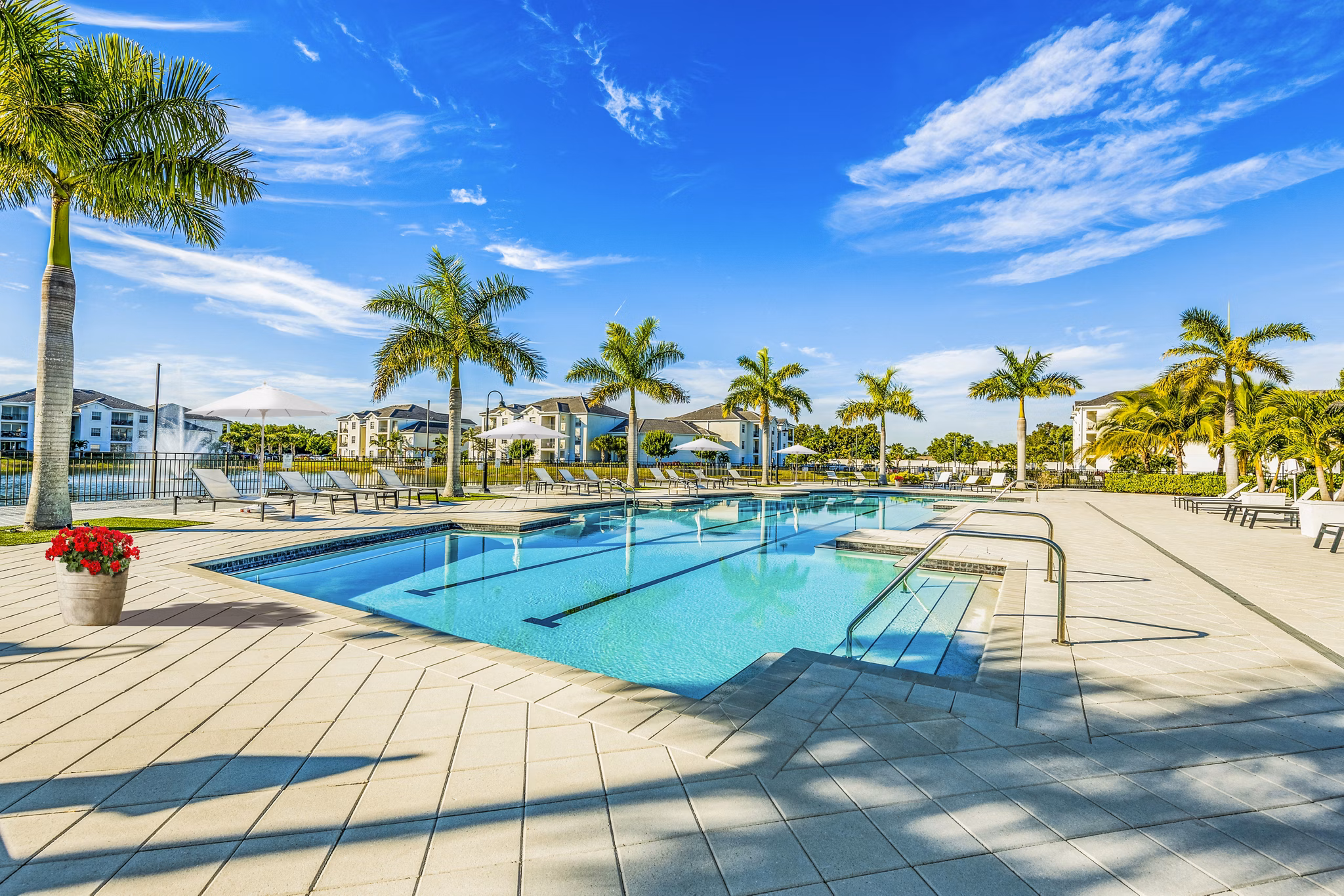 Resort-style pool with lounge chairs at Estero Oaks Apartments offering luxury living