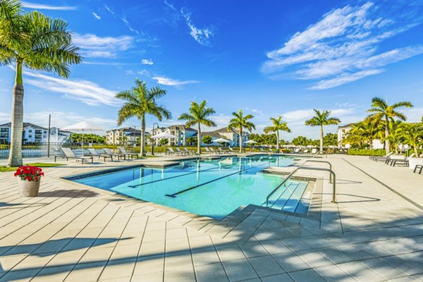 Resort-style pool with lounge chairs at Estero Oaks Apartments offering luxury living