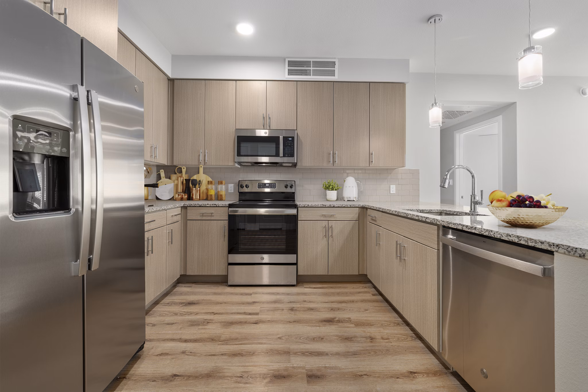 Modern kitchen with granite countertops and stainless steel appliances in Album Marana Apartments