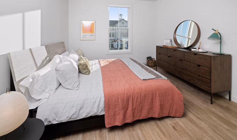 Cozy bedroom with contemporary design and large windows at Darien Commons Apartments