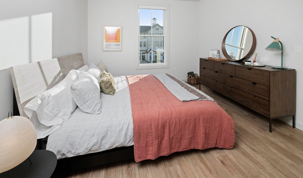 Cozy bedroom with contemporary design and large windows at Darien Commons Apartments
