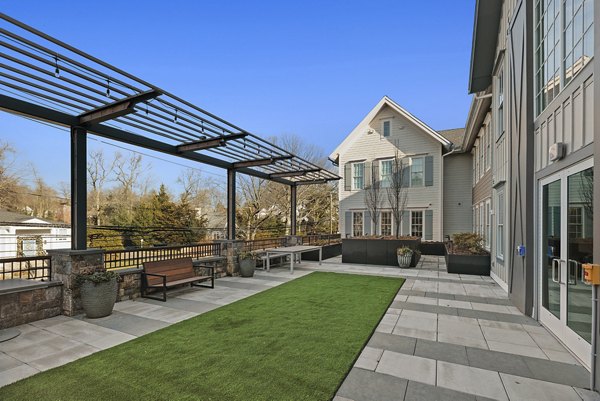 Chic outdoor patio at Darien Commons Apartments featuring cozy seating and greenery