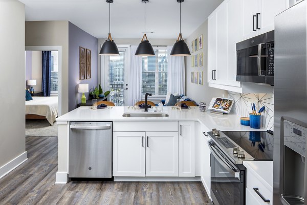 Modern kitchen with stainless steel appliances and marble countertops at Broadstone SoBro Apartments