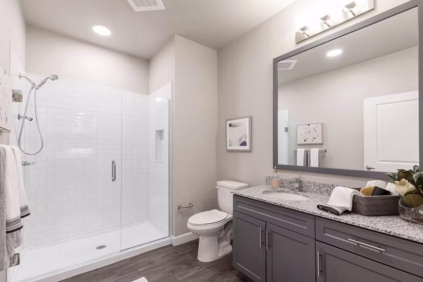 Bathroom featuring sleek fixtures and marble countertops in Avenida at Centerra Apartments