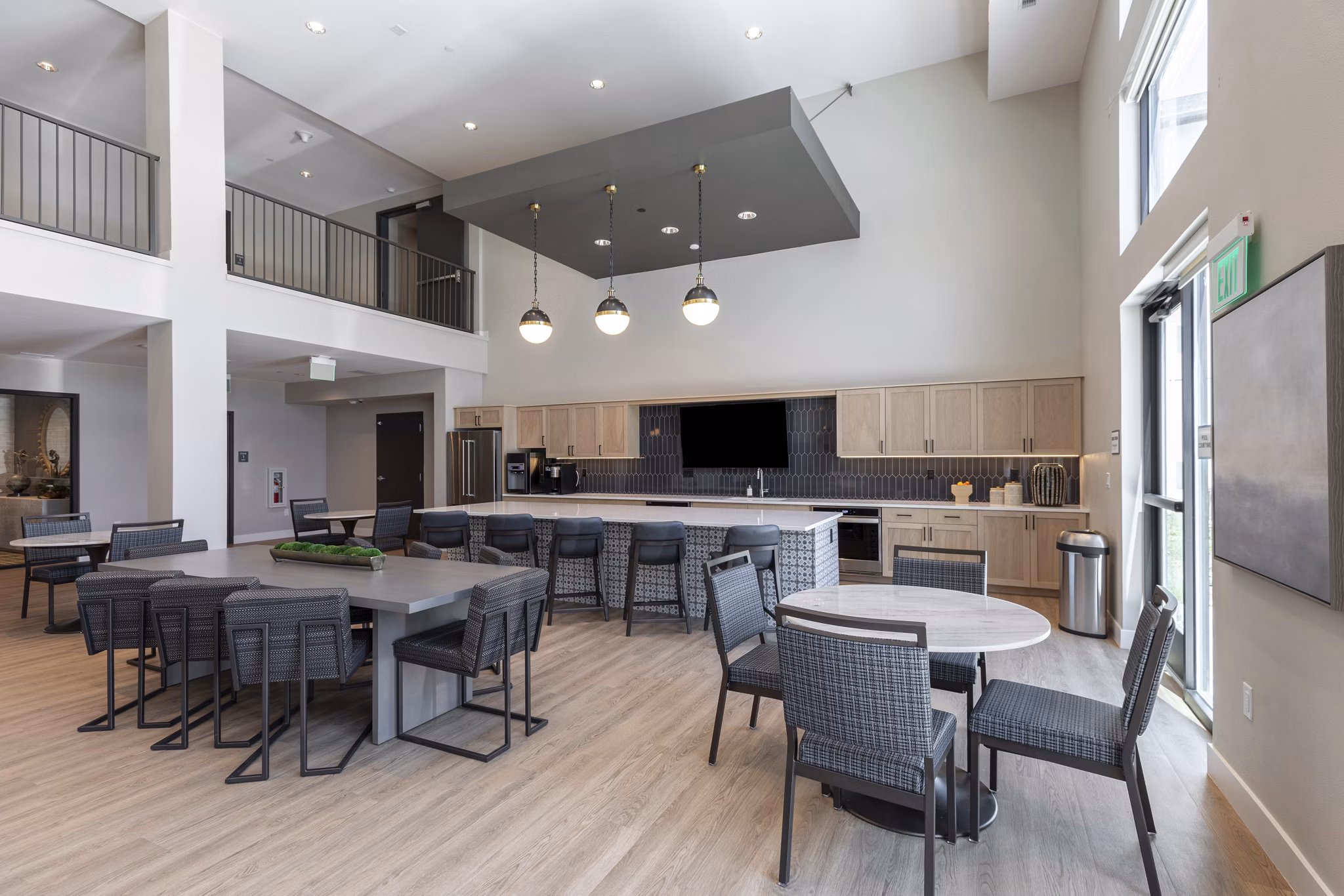 Avenida at Centerra Apartments: Modern clubhouse featuring stylish seating and a fireplace in a luxury setting