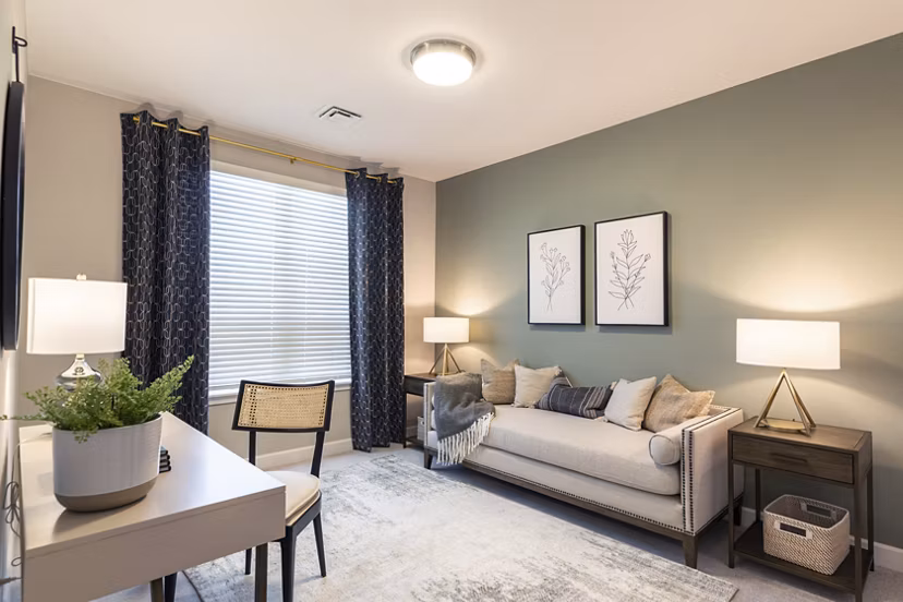 Home office featuring modern desk and cozy seating in Avenida at Centerra Apartments Ideal for remote work with ample natural light