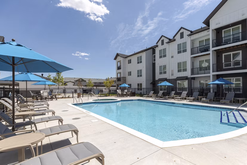 Relaxing pool area with seating and landscaping at Avenida at Centerra Apartments, perfect for luxury living and outdoor enjoyment