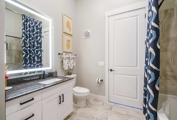 Bathroom featuring modern fixtures and elegant tiling at Cadence at Frisco Station Apartments
