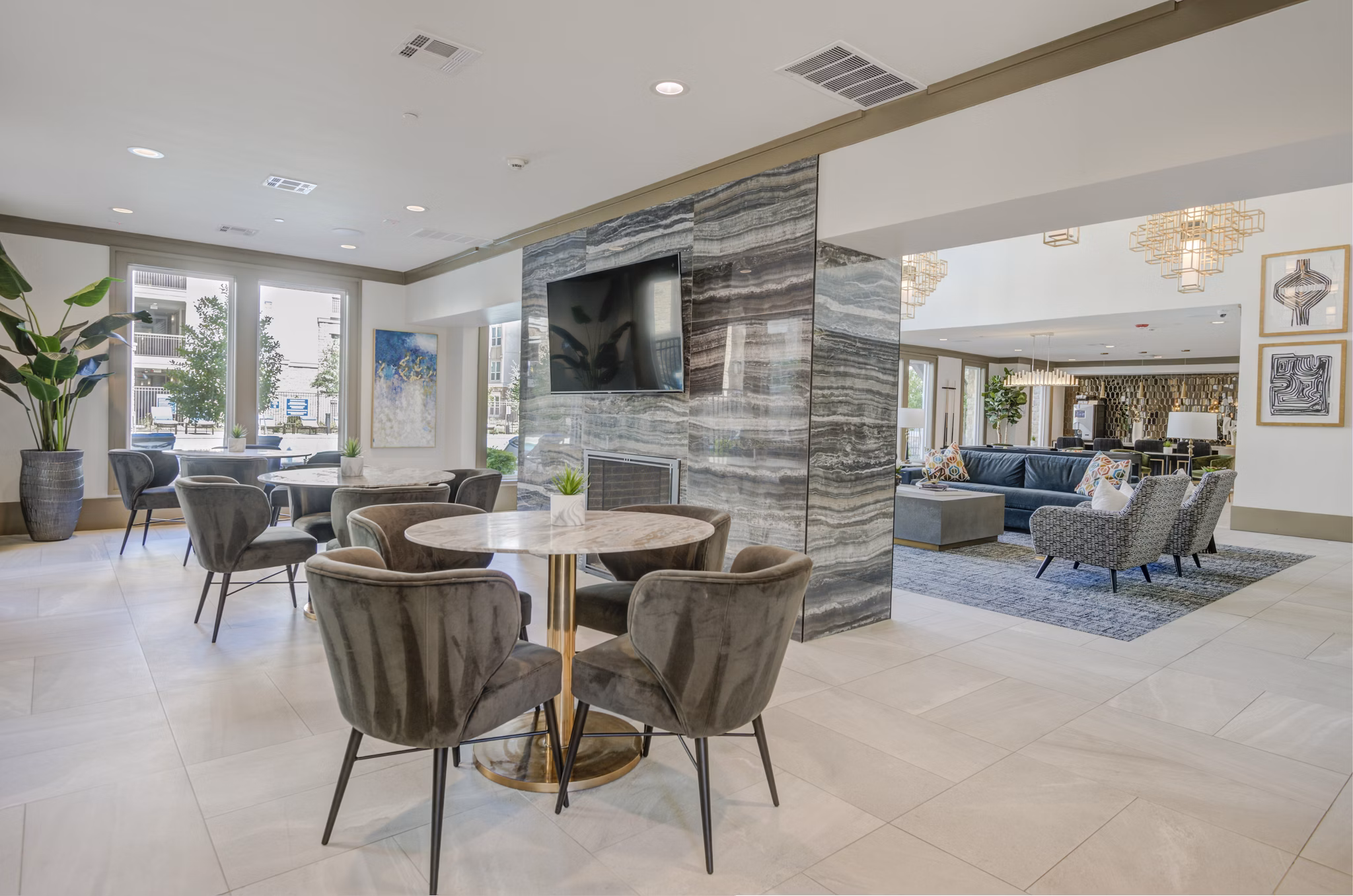 Modern clubhouse featuring lounge seating and large windows at The Link at Twin Creeks Apartments