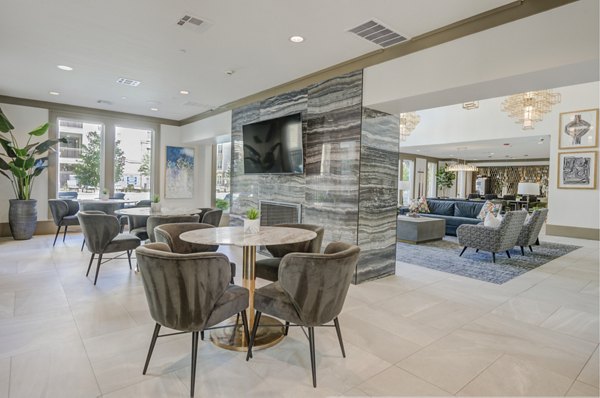 Modern clubhouse featuring lounge seating and large windows at The Link at Twin Creeks Apartments
