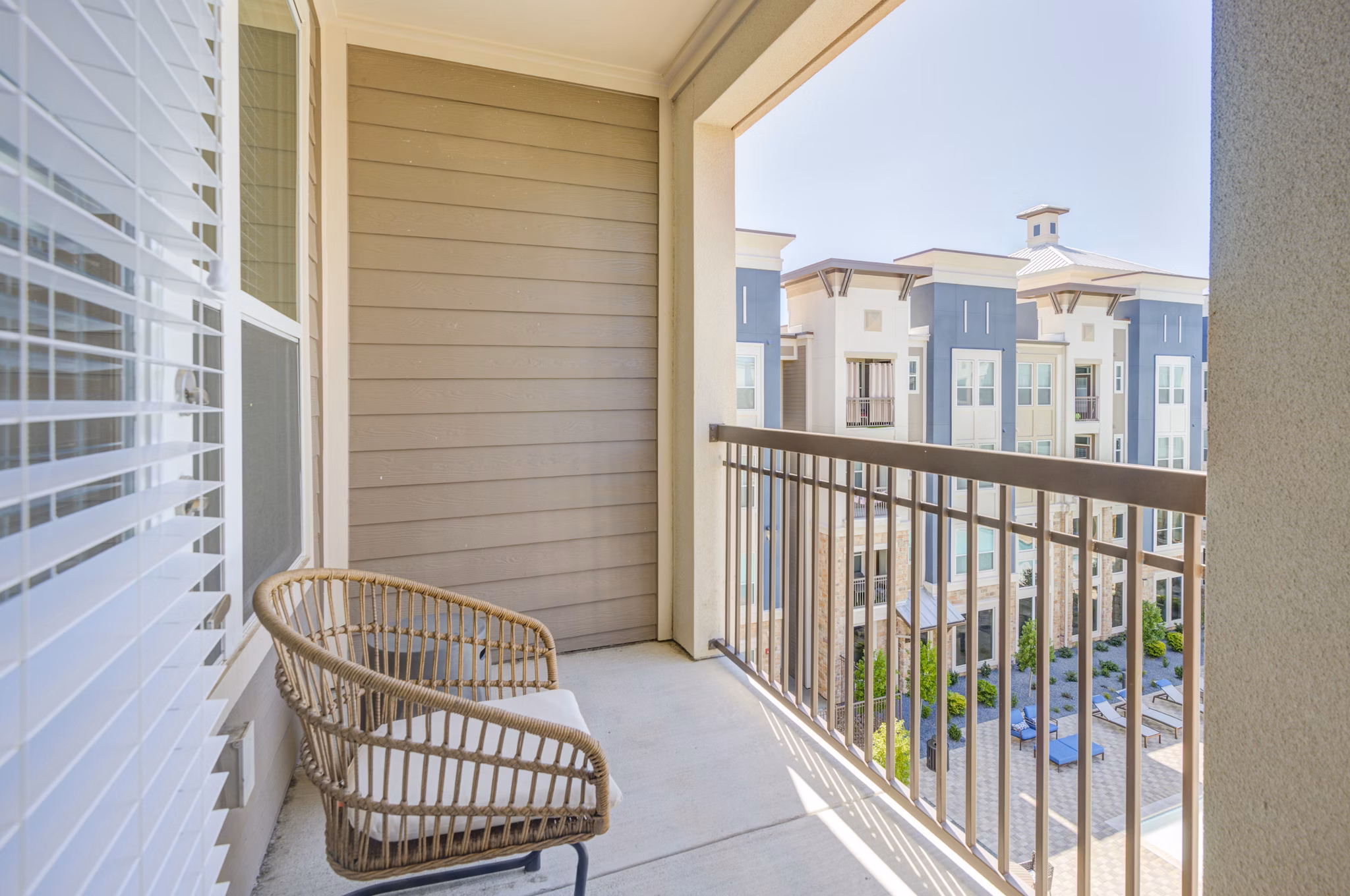 Cozy patio with seating and garden views at The Link at Twin Creeks Apartments