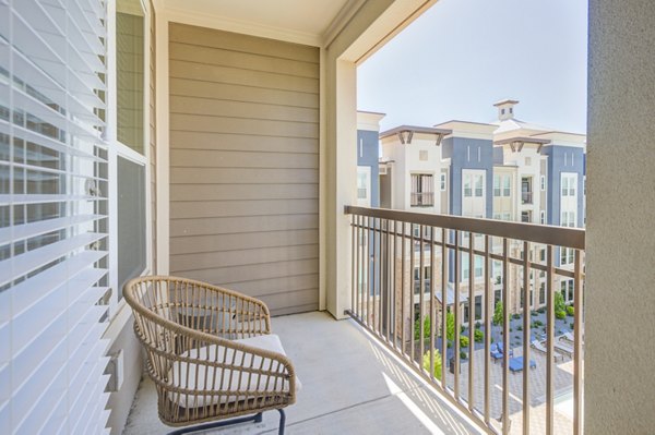 Cozy patio with seating and garden views at The Link at Twin Creeks Apartments