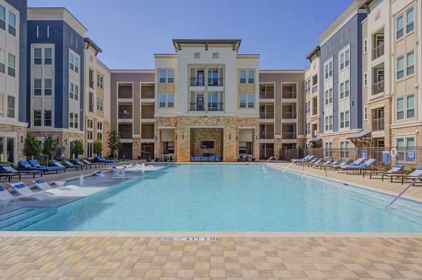 Resort-style pool with lounging areas at The Link at Twin Creeks Apartments