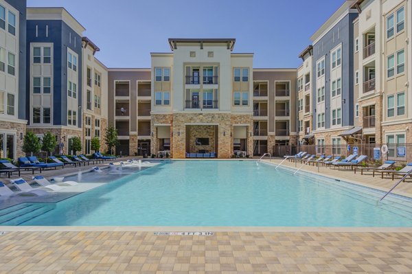 Resort-style pool with lounging areas at The Link at Twin Creeks Apartments