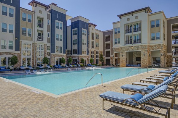 Inviting swimming pool at The Link at Twin Creeks Apartments with lounge seating