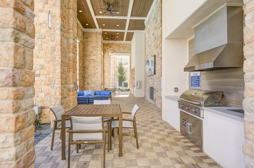 Grill area with modern outdoor seating at The Link at Twin Creeks Apartments, a luxury community offering premier amenities for residents