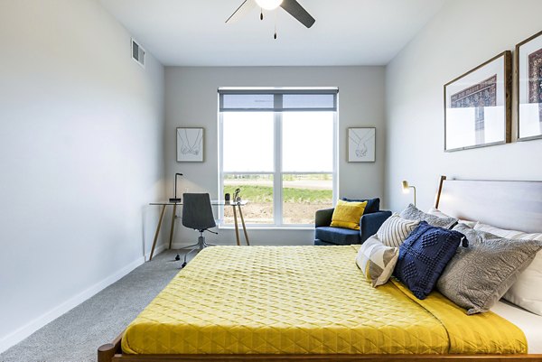 Cozy bedroom with modern design and plush bedding at Beyond Woodbury Apartments