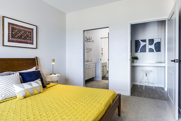 Cozy bedroom with plush bedding and modern decor at Beyond Woodbury Apartments