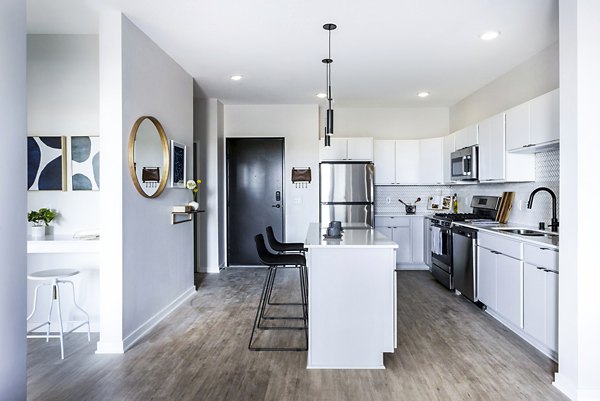 Modern kitchen with stainless steel appliances in Beyond Woodbury Apartments