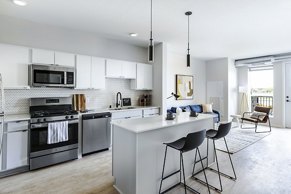 Modern kitchen with sleek countertops and stainless steel appliances at Beyond Woodbury Apartments