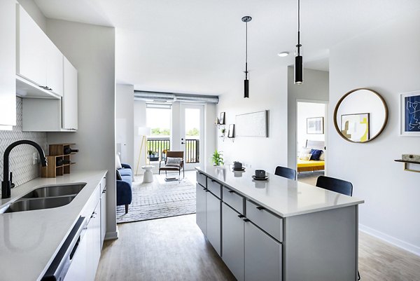 Modern kitchen featuring sleek cabinetry and stainless steel appliances at Beyond Woodbury Apartments