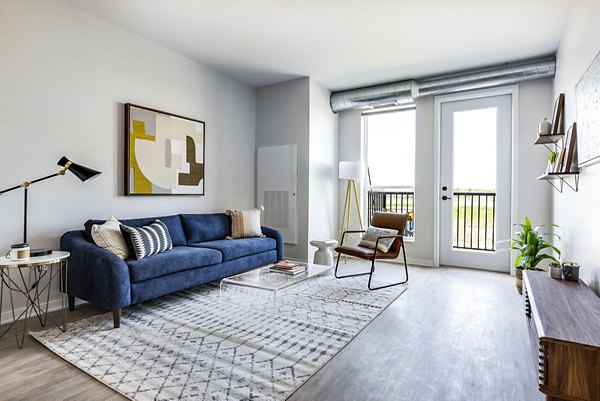 Spacious living room with modern decor in Beyond Woodbury Apartments, featuring natural light and open layout for luxury living