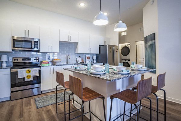 Dining room and kitchen featuring modern appliances at The Accolade Collegiate Village West Apartments