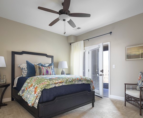 Inviting bedroom with plush bedding and large windows at Savannah West Apartments