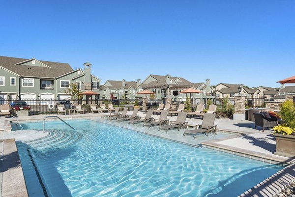 Luxurious pool area at Savannah West Apartments featuring comfortable lounge chairs and lush greenery